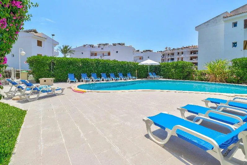 02_apartamentos_llevant_Enjoy_2026 Solárium con hamacas junto a la piscina de Apartamentos Llevant